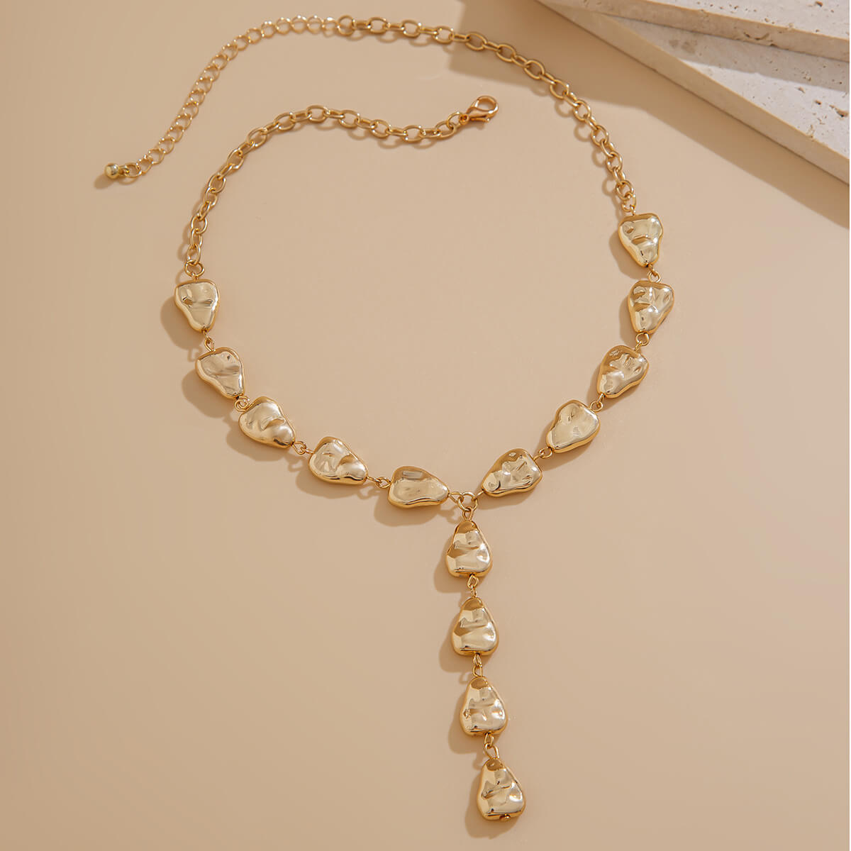 Gold Y-necklace with irregular organic-shaped charms and adjustable chain